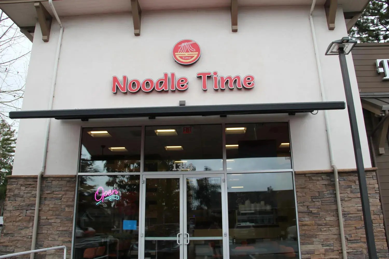 Exterior of Noodle Time restaurant, with "Open" sign 